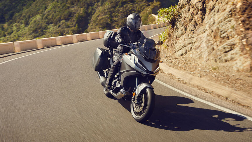 Moto routière Honda NT1100 mettant en avant la protection contre le vent et les dimensions compactes.