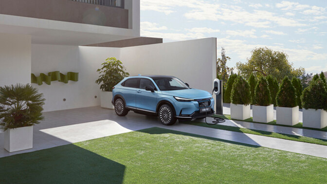 Three-quarters rear view Honda-e in a street with trafic lights